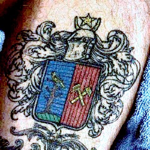 Photograph of the Mumma Coat of Arms tattooed on the leg of Craig Mumma It